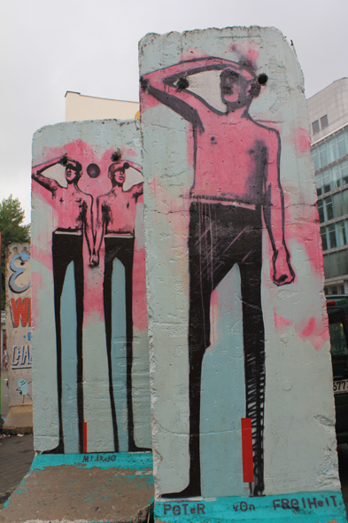 Des dessins d'hommes sur le mur de Berlin